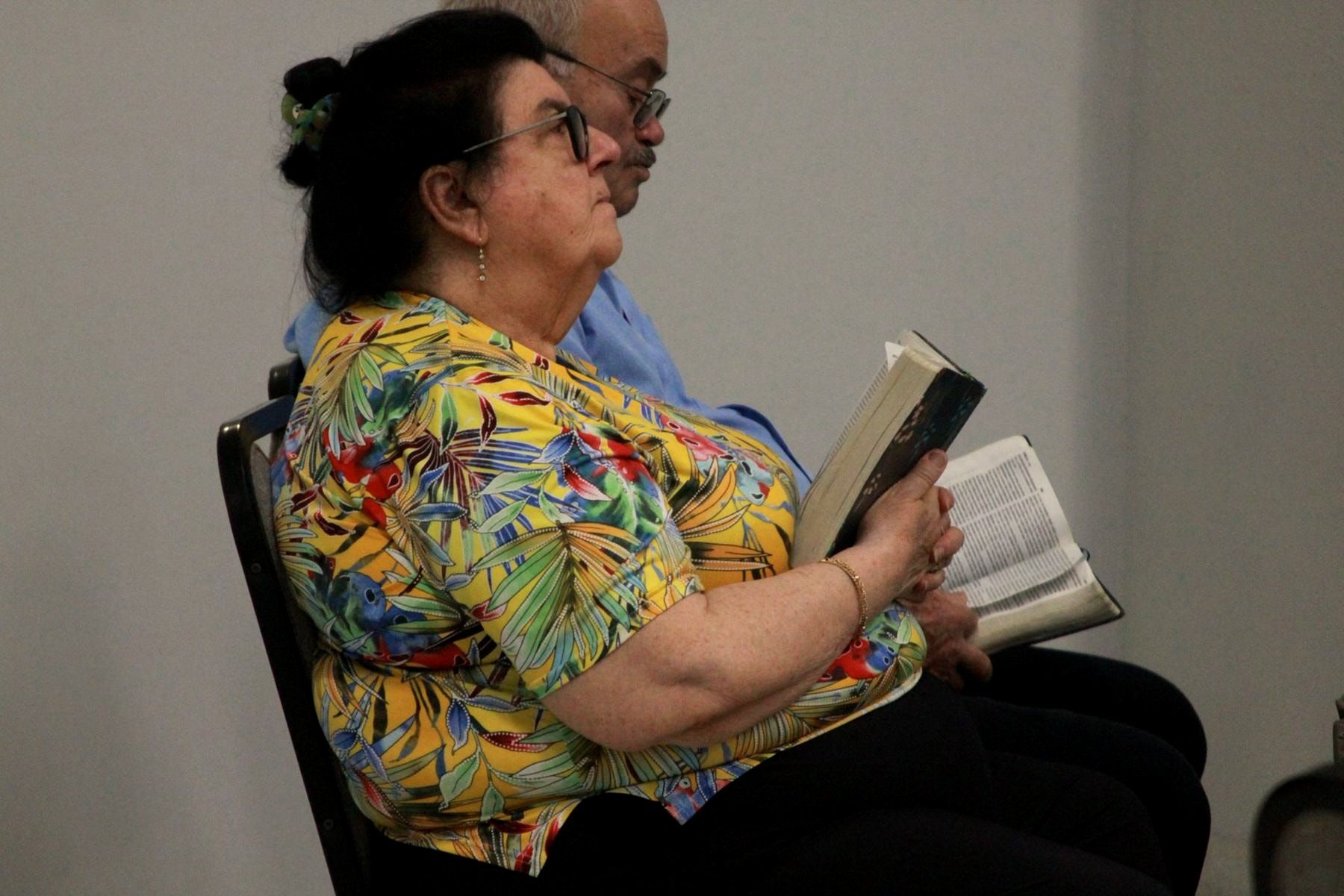 Uma senhora a ler a Bíblia durante o culto